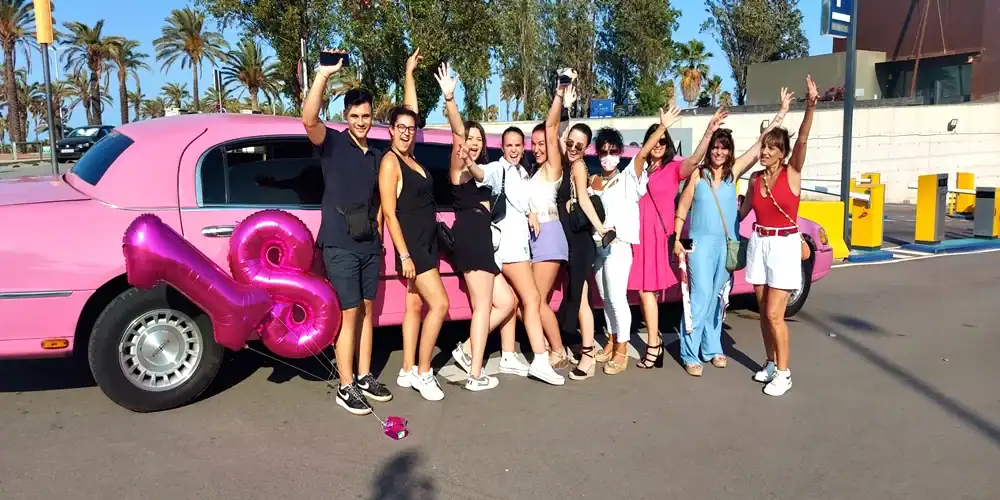 Grupo celebrando un cumpleaños de 18 años en una limusina Lincoln rosa