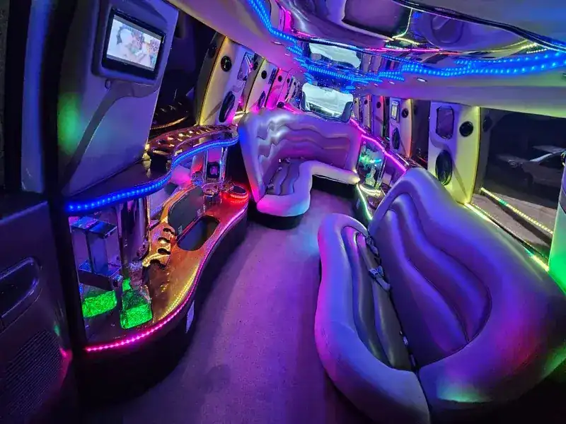 Interior de limusina Ford Hummer blanca con sistema de sonido premium y luces LED de ambiente