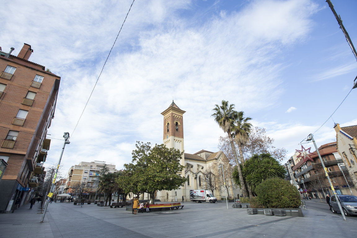 Limusina blanca de lujo circulando por una avenida de Cerdanyola del Vallès con luces cálidas al atardecer, ofreciendo servicio exclusivo de alquiler de limusinas en la zona.