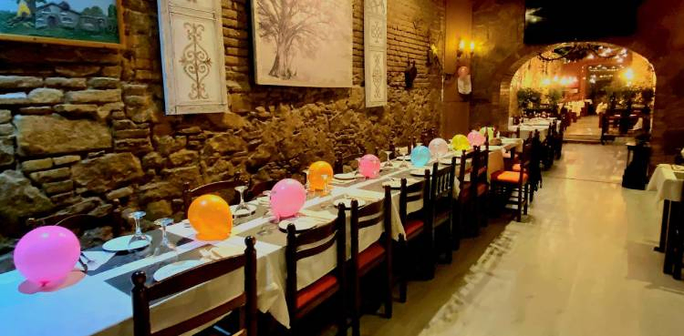 Dip2026a Grupo de amigos celebrando un cumpleaños en un restaurante decorado con globos y detalles festivos en Barcelona, tras llegar en una limusina con chófer para disfrutar de una experiencia VIP.