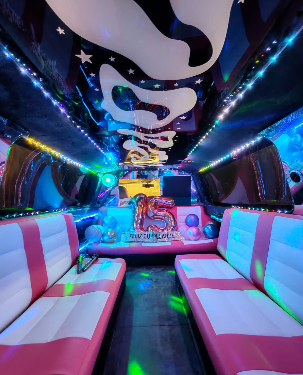 interior rosa grande limusina Quinceañera celebrando su cumpleaños de 15 años junto a sus damas de honor en una limusina rosa.